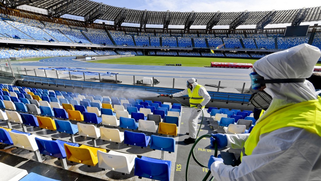 (FILES) In this file photo taken on March 04, 2020 Picture taken on March 4, 2020 shows cleaners wearing a protective suit, as they sanitise the seats of the San Paolo stadium in Naples. - Hiring is surging and wages are rising in the United States as the year begins, but the coronavirus is poised to infect the economy and hamper President Donald Trump's re-election bid. Wall Street has tumbled in recent days as the outbreak spread and undermined the view that the US economy is inoculated against the danger. The White House has tried to downplay the impact, and Trump on march 6, 2020 even made the extraordinary claim that US businesses are benefitting from people staying in the country while predicting stocks would bounce back. (Photo by CIRO FUSCO / ANSA / AFP) / - Italy OUT